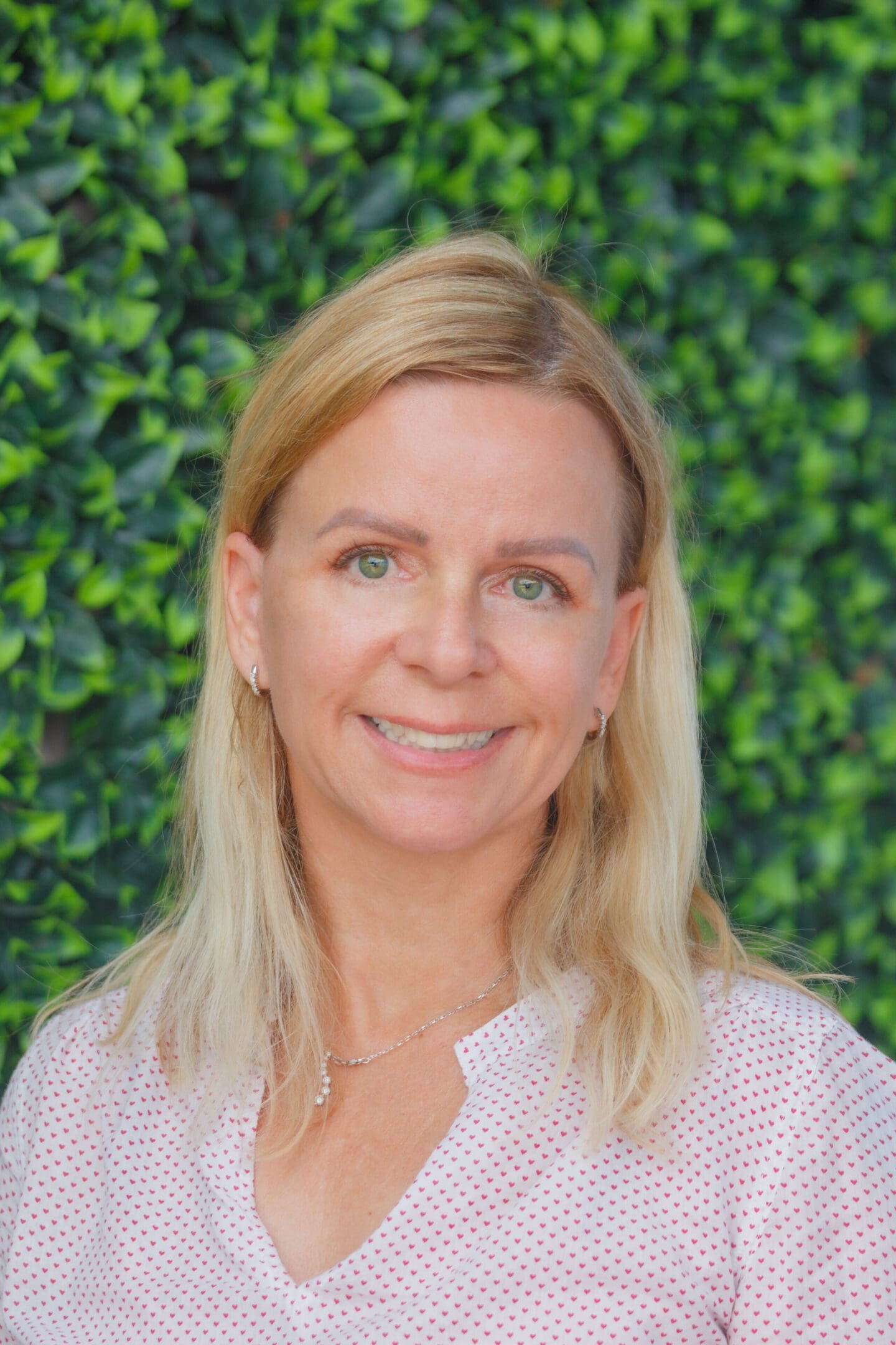 A woman standing in front of a green wall.