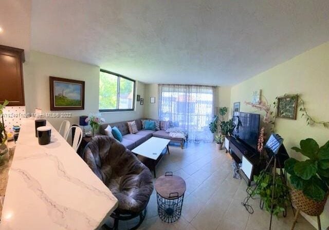 A living room with couches, tables and a television.