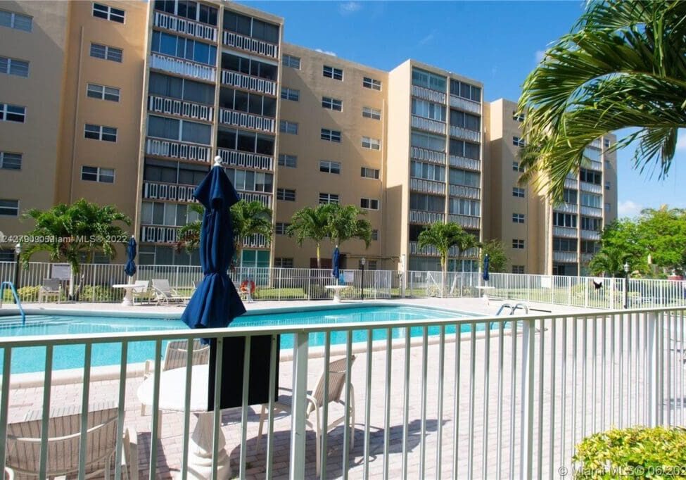 A pool with a view of the apartment complex.