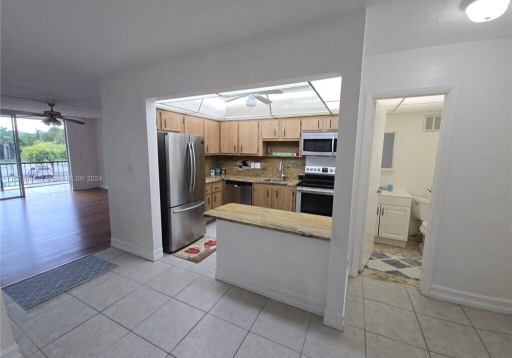 A kitchen with tile floors and white walls.