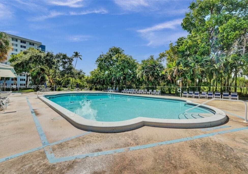 A pool with trees in the background and blue sky